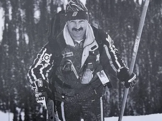 Gottfried Trinkl in Skibekleidung an der Piste, einen Skistock in der Hand.