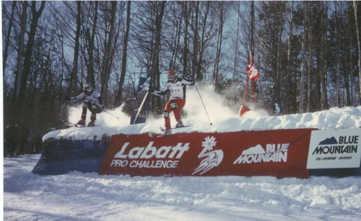 Zwei Rennläufer springen nebeneinander über eine Schanze mit der Aufschrift „Labatt Pro Challenge, Blue Mountain“.